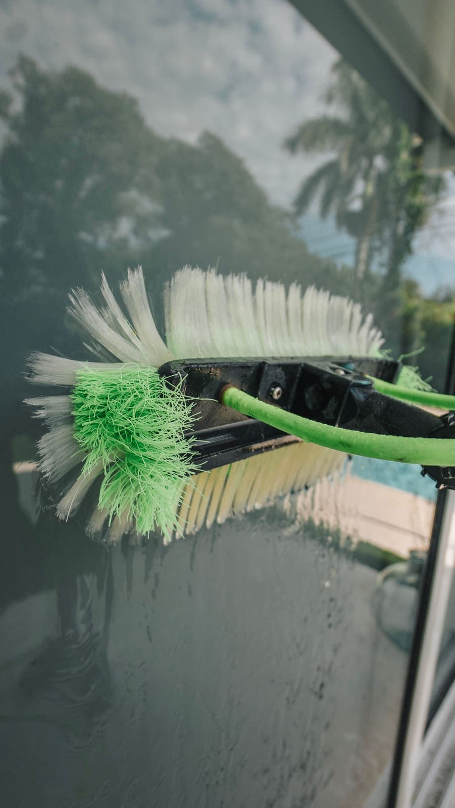 Water-fed pole brush working a glass door on a Miami home