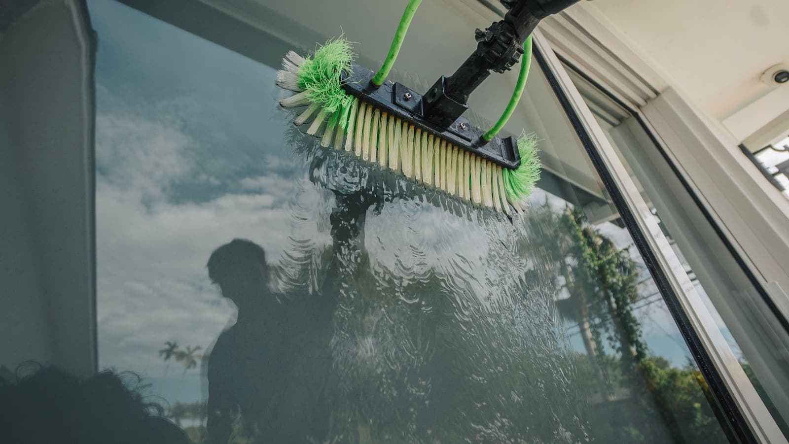 Pure water sheeting off the glass as the brush rinses from below